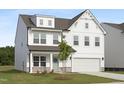 Two-story home features a crisp white facade, an attached two-car garage, well-maintained lawn, and welcoming entry at 88 Mable Court # 17, Lillington, NC 27546