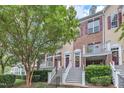 View of inviting townhomes with brick and siding, featuring landscaped frontages and welcoming stairways to covered entrances at 9211 Calabria Dr # 104, Raleigh, NC 27617