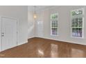 Bright, airy living room with gleaming hardwood floors, high ceilings, and large windows that fill the space with natural light at 9211 Calabria Dr # 104, Raleigh, NC 27617