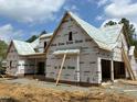 New construction home featuring wood framing, protective wraps, and a modern design at 93 Bur Oak Ct, Pittsboro, NC 27312