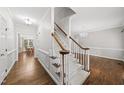 Bright foyer featuring hardwood floors, staircase with carpeted steps, and elegant trim work at 1007 Surry Dale Ct, Apex, NC 27502