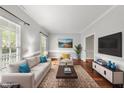 Cozy living room with large windows, neutral decor, and hardwood flooring at 1007 Surry Dale Ct, Apex, NC 27502