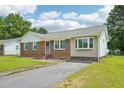 Traditional brick house with green shutters, bay window, and a paved driveway at 102 Pine St, Dunn, NC 28334
