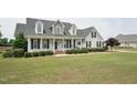 Charming two-story home with a welcoming front porch, manicured lawn, and classic black shutters at 105 Bagley Ln, Dunn, NC 28334