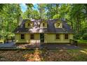 Charming two-story home with dormer windows and a welcoming deck, surrounded by beautiful mature trees at 106 Redbud, Pittsboro, NC 27312