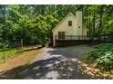 Quaint home with a spacious backyard, a deck, and a private gravel driveway surrounded by lush greenery at 106 Redbud, Pittsboro, NC 27312