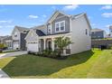 Charming two-story home with a well-manicured lawn, white garage door, and covered front porch at 1165 Sun Spgs Rd, Wake Forest, NC 27587
