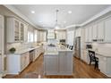 Bright kitchen featuring custom cabinets, granite counters, stainless steel appliances and hardwood floors at 117 Synandra Ln, Holly Springs, NC 27540