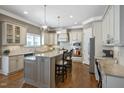 Spacious kitchen featuring bar stool seating, stainless appliances, and hardwood floors at 117 Synandra Ln, Holly Springs, NC 27540