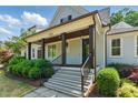 Inviting front porch with dark wood beams, stone steps and black iron handrail at 125 Lord Ashley Rd, Raleigh, NC 27610