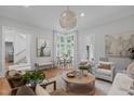 Sun-filled living room showcasing a unique round chandelier and a cozy seating area at 1305 Queensferry Rd, Cary, NC 27511