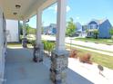 Spacious covered porch boasting stylish stone pillars and views of the peaceful neighborhood at 1311 Arena Ln, Fuquay Varina, NC 27526