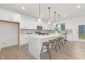 Bright, modern kitchen featuring a large island, stylish pendant lighting, and stainless steel appliances at 140 Summer Mist Ln # 159, Clayton, NC 27527