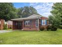 Charming one-story brick home with a cozy front porch and well-maintained lawn at 1416 Chestnut St, Roxboro, NC 27573