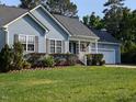 Charming home featuring a well-manicured lawn, attached garage, and delightful front porch at 154 Hillsdale Dr, Archer Lodge, NC 27527