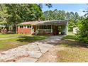 View of a traditional brick home with an attached carport and mature landscaping at 1709 Whitfield Ave, Rocky Mount, NC 27801