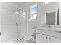Well-lit bathroom featuring white cabinets, a glass-enclosed shower, and a window at 1900 Fishamble St # 17, Fuquay Varina, NC 27526