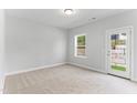 Bright bedroom featuring a door to the outside and a window with a view of the backyard at 1900 Fishamble St # 17, Fuquay Varina, NC 27526