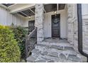 Inviting front entrance with stone steps, decorative wreath, and covered porch with pendant lights at 2004 Yamacraw Dr, Knightdale, NC 27545