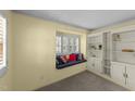 Cozy living room showcasing a window seat with colorful cushions and built-in shelving for storage at 205 W Oak Ave, Wake Forest, NC 27587