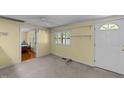 A bright living room with fresh paint and entry door, complete with neutral carpet and open access to adjacent rooms at 205 W Oak Ave, Wake Forest, NC 27587