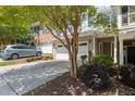 A view of a charming townhome with brick and siding, featuring a two-car garage and landscaped front yard at 2082 Weston Green Loop Loop, Cary, NC 27513