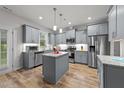 Modern kitchen featuring stainless steel appliances, gray cabinetry, granite countertops, and center island at 24 W Catalina Ct, Clayton, NC 27527