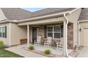 Inviting front porch with stone accents, white rocking chairs, and well-maintained landscaping at 24 W Catalina Ct, Clayton, NC 27527