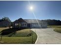 Charming exterior elevation of a new home with a three car garage and a well maintained lawn at 240 Eason Creek Way, Clayton, NC 27527