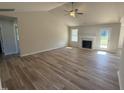 Bright living room featuring hardwood floors, a fireplace, ceiling fan, and an open floorplan at 240 Eason Creek Way, Clayton, NC 27527