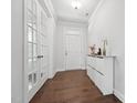 Inviting foyer featuring hardwood floors, a closet cabinet, and a bright white front door with glass panels at 241 Fishburn Dr, Apex, NC 27523