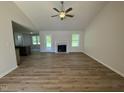 Bright open-concept living space with modern wood flooring and a charming fireplace at 245 Eason Creek Way, Clayton, NC 27527