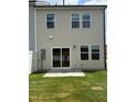 This home's backyard features a sliding glass door to a patio, and a well-maintained lawn at 253 Hank Way, Angier, NC 27501