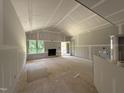 Spacious living room with fireplace, abundant natural light, and unfinished floors at 2760 Rains Mill Rd, Princeton, NC 27569