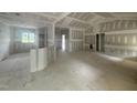 Open-concept living room and kitchen area with high ceilings and large windows. Unfinished at 2760 Rains Mill Rd, Princeton, NC 27569