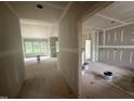 Spacious interior of a home under construction with drywall installed, offering a glimpse of the outdoors through the windows at 2776 Rains Mill Rd, Princeton, NC 27569