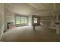 Open-concept living room with a fireplace, drywall, and lots of natural light at 2776 Rains Mill Rd, Princeton, NC 27569