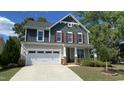 Charming two-story home featuring a manicured lawn, attached garage, and inviting front porch at 2855 Wilkes Lake Dr, Fuquay Varina, NC 27526