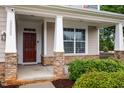 Cozy front porch with stone pillars and an inviting deep red front door at 2855 Wilkes Lake Dr, Fuquay Varina, NC 27526