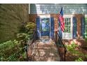 Inviting entryway with brick steps leading to a blue front door with an American flag at 3025 Wycliff Rd, Raleigh, NC 27607