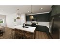 Modern kitchen featuring green cabinets, white countertops, and wooden island with seating at 323 Beacon Dr, Pittsboro, NC 27312
