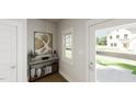 Bright foyer with a console table, stylish decor, and a view to the front yard through the glass-paneled front door at 339 Beacon Dr, Pittsboro, NC 27312