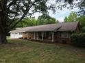 Charming brick ranch-style home with attached garage, mature trees and a well-manicured lawn at 3669 W Greensboro Chapel Hill Rd, Liberty, NC 27298
