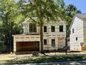 New construction home with unfinished exterior and large tree in front yard at 3828 Coach Lantern Ave, Wake Forest, NC 27587