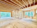 Unfinished living room with exposed beams and framing, offering a spacious open floor plan with natural light at 3828 Coach Lantern Ave, Wake Forest, NC 27587