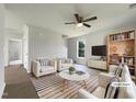 Bright living room with modern furniture, ceiling fan, and large windows offering natural light at 4025 Scofield Dr, Raleigh, NC 27610