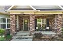 Inviting front porch with brick pillars, seating, and a welcoming entrance at 4036 Mackenzie Dr, Haw River, NC 27258
