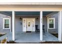 Inviting front porch with white columns, seating, and a charming entrance door at 411 E Green St, Franklinton, NC 27525