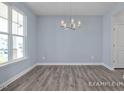 Well-lit dining area with wood-look floors and a stylish chandelier at 422 Grading Stick Ct, Angier, NC 27501