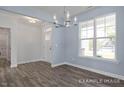 Inviting dining space featuring light blue walls, wood-look floors, and a modern chandelier at 422 Grading Stick Ct, Angier, NC 27501